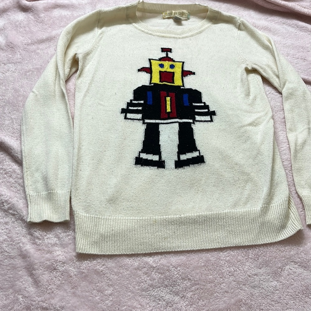 White sweater with robot in front.